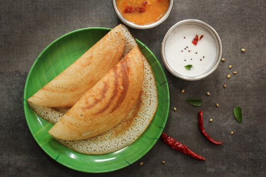 Golden dosas served with chutney and sambar.